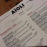 Menu Aïoli z opisami dań, w tym burgerów i śniadań.