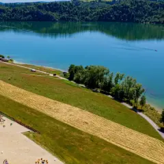 Malownicze jezioro czorsztyńskie z widokiem na domki, plac zabaw i plażę. Idealne miejsce na wypoczynek i odkrywanie atrakcji.
