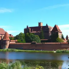 Potężny zamek w Malborku nad jeziorem. Zwiedzanie zamku w Malborku to podróż w czasie, warto zaplanować cały dzień.