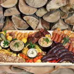 Bogata deska mięs i dodatków, idealna na rodzinne spotkanie. Sprawdź borowa chata menu cennik i zarezerwuj swój stolik!