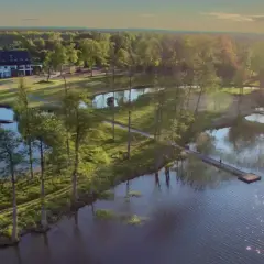 Malowniczy widok na jezioro i hotel, idealne miejsce, gdzie na Mazury. Słońce odbija się w wodzie, tworząc magiczny blask.