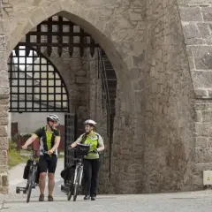 Para rowerzystów w kaskach pod kamiennym łukiem, gotowi na chańcza zalew trasę.
