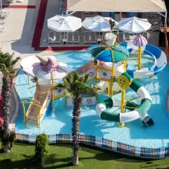 Kolorowy aquapark w Orange County Belek, z palmami i zjeżdżalniami, zaprasza do zabawy.