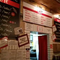 Wnętrze pijalni wódki i piwa. Menu z napojami i przekąskami na tablicach.