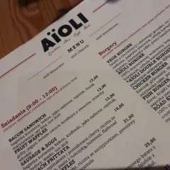 Menu Aïoli z opisami dań, w tym burgerów i śniadań.