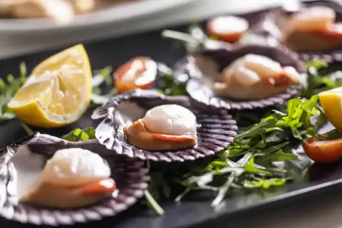Wykwintne przegrzebki na talerzu, jak w najlepszej restauracji francuskiej. Podane z rukolą, pomidorkami i cytryną.
