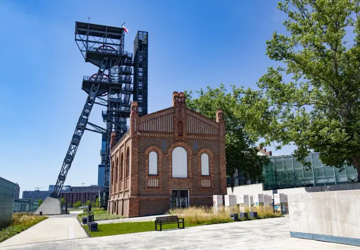 Dawna wieża szybu kopalnianego i ceglany budynek tworzą nietypowe atrakcje Katowice.