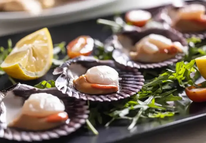 Wykwintne przegrzebki na talerzu, jak w najlepszej restauracji francuskiej. Podane z rukolą, pomidorkami i cytryną.