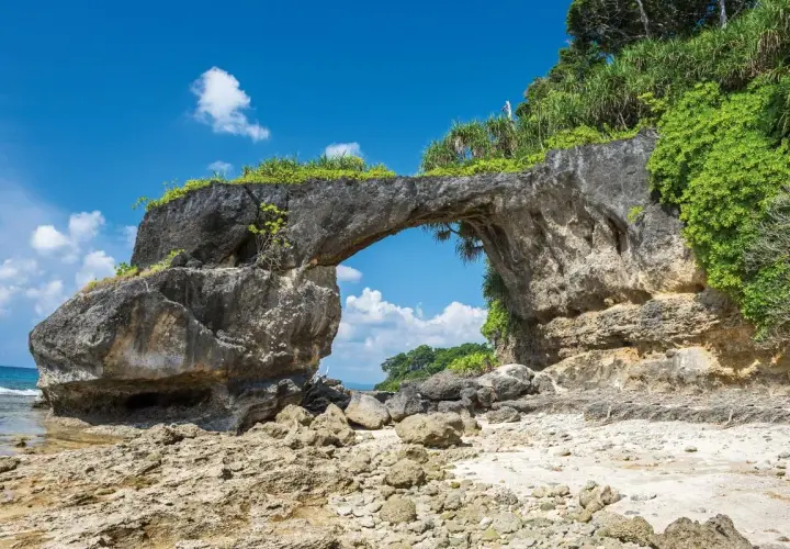 Skalny łuk na plaży, jakby stworzony przez naturę na Andamanach. Słońce, morze i bujna roślinność.