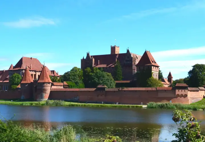 Potężny zamek w Malborku nad jeziorem. Zwiedzanie zamku w Malborku to podróż w czasie, warto zaplanować cały dzień.