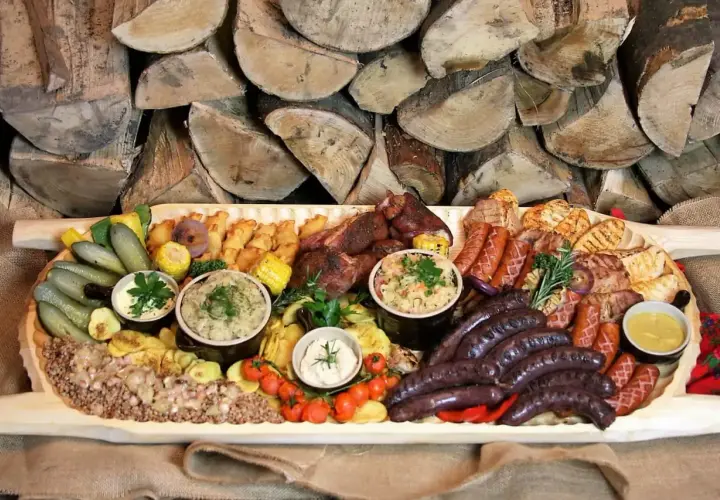Bogata deska mięs i dodatków, idealna na rodzinne spotkanie. Sprawdź borowa chata menu cennik i zarezerwuj swój stolik!