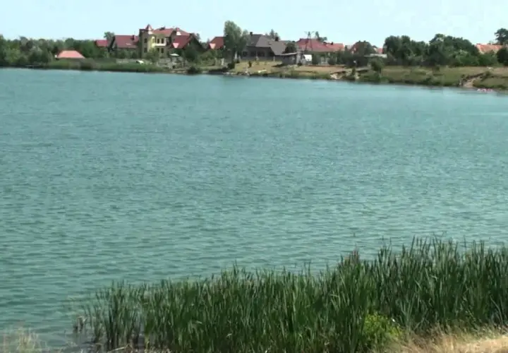 Spalona jezioro z domami na brzegu i trzcinami.