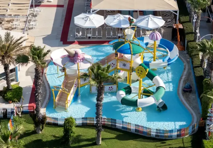 Kolorowy aquapark w Orange County Belek, z palmami i zjeżdżalniami, zaprasza do zabawy.