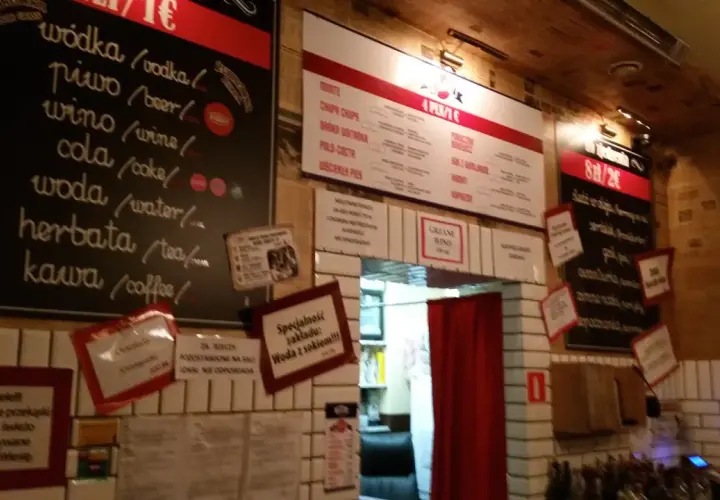 Wnętrze pijalni wódki i piwa. Menu z napojami i przekąskami na tablicach.