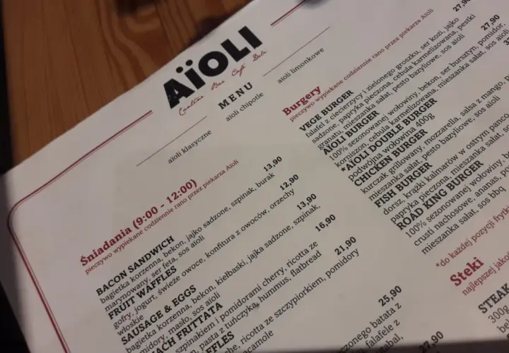 Menu Aïoli z opisami dań, w tym burgerów i śniadań.