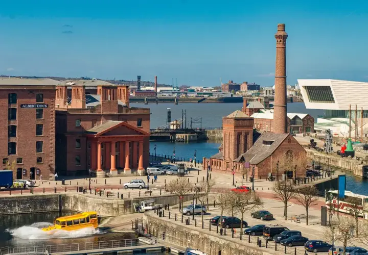 Albert Dock w Liverpool miasto, z żółtym amfibią w wodzie i charakterystycznym kominem.