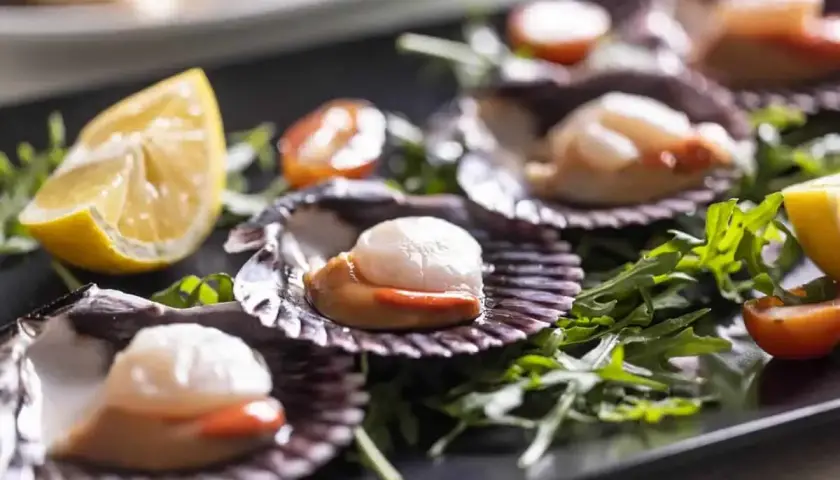 Wykwintne przegrzebki na talerzu, jak w najlepszej restauracji francuskiej. Podane z rukolą, pomidorkami i cytryną.