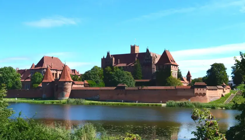 Potężny zamek w Malborku nad jeziorem. Zwiedzanie zamku w Malborku to podróż w czasie, warto zaplanować cały dzień.