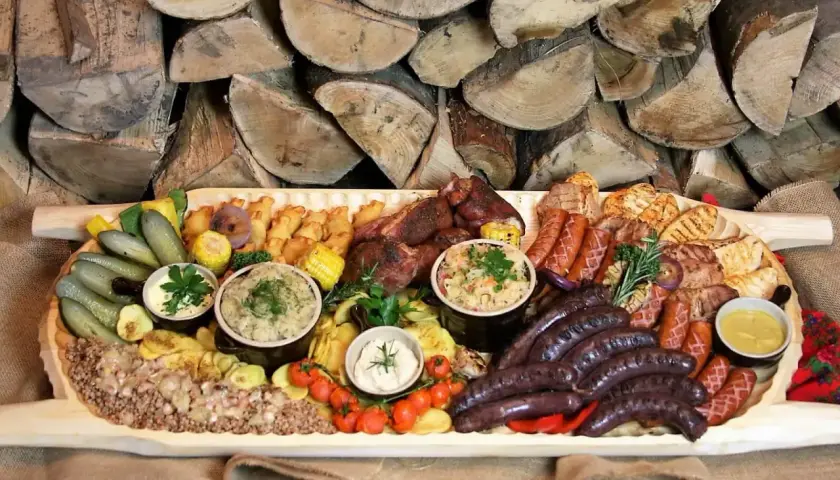 Bogata deska mięs i dodatków, idealna na rodzinne spotkanie. Sprawdź borowa chata menu cennik i zarezerwuj swój stolik!