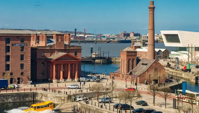 Albert Dock w Liverpool miasto, z żółtym amfibią w wodzie i charakterystycznym kominem.