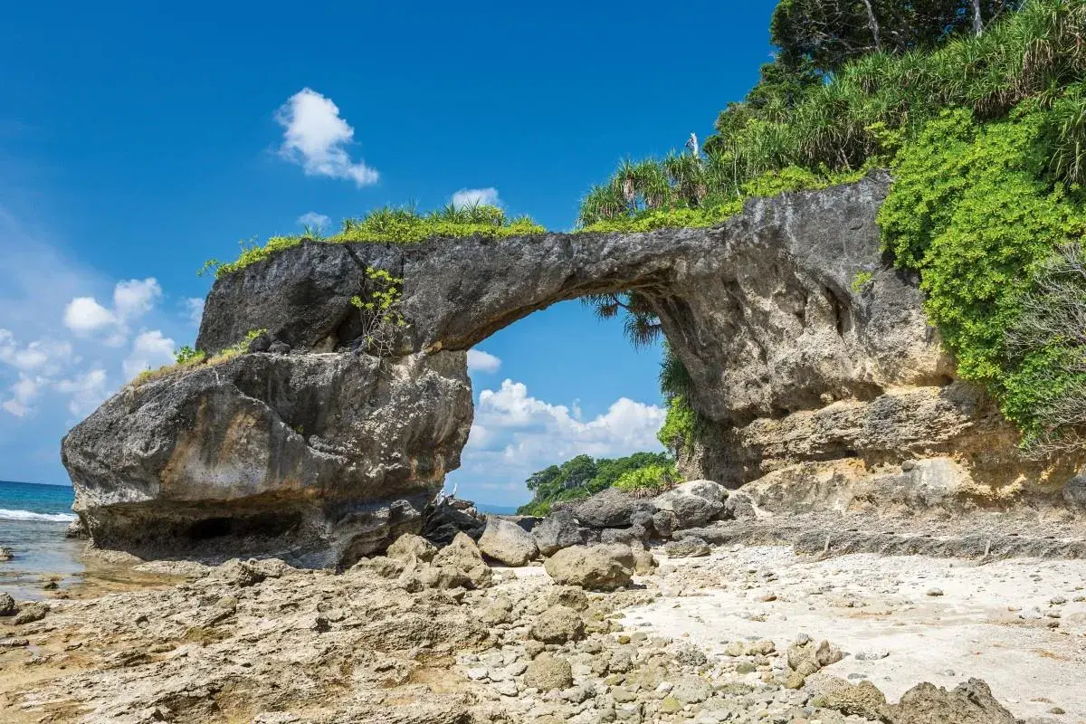 Skalny łuk na plaży, jakby stworzony przez naturę na Andamanach. Słońce, morze i bujna roślinność.