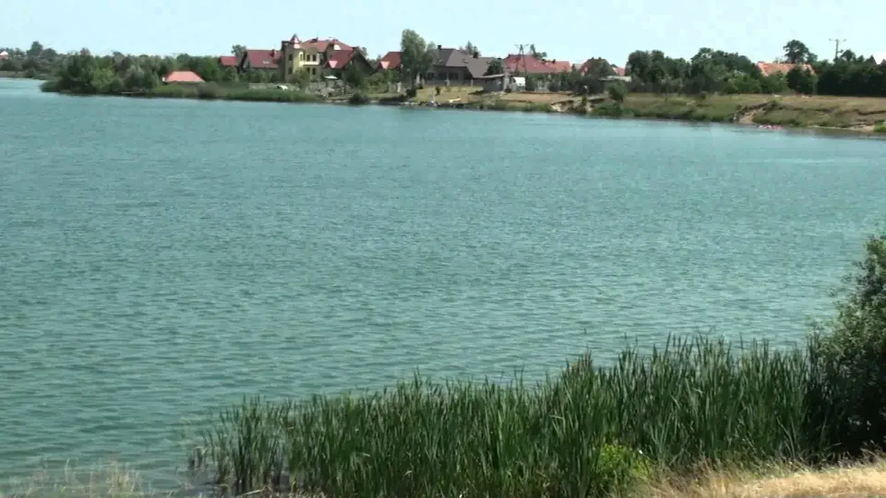 Spalona jezioro z domami na brzegu i trzcinami.