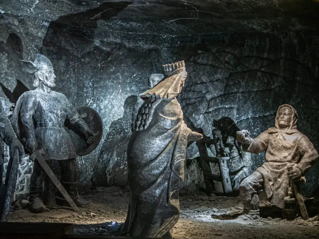 Solne rzeźby w kopalni w Wieliczce. Postacie z historii miasta Wieliczka, wyrzeźbione w soli, stoją w mrocznych korytarzach.