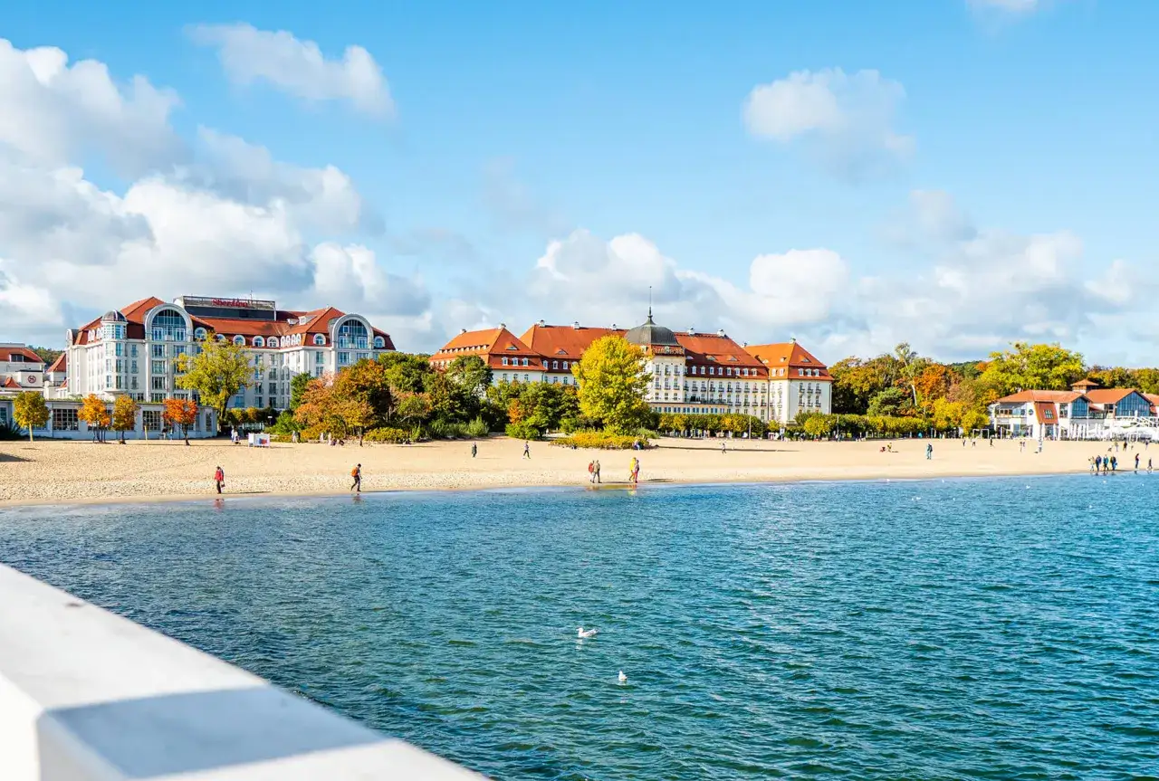 Piękny pokój nad morzem z widokiem na plażę i hotele w Sopocie. Jesienne drzewa dodają uroku.