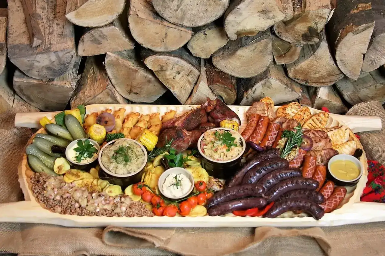 Borowa chata menu cennik: ogromna deska mięs, kiełbasek, ziemniaków, ogórków i surówek. Idealna na wspólny posiłek.